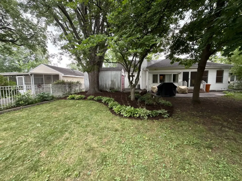 Clean landscaped backyard garden beds with fresh mulch and plants